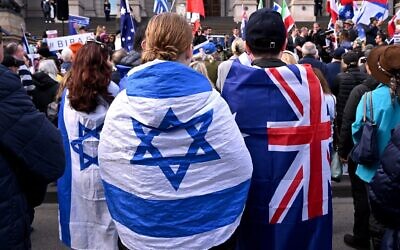 FILE: People wearing flags of Israel and Australia listen to speeches at a rally in Melbourne on July 6, 2025, after the front door of a synagogue was set ablaze // Photo Credit: WILLIAM WEST/AFP/Times of Israel