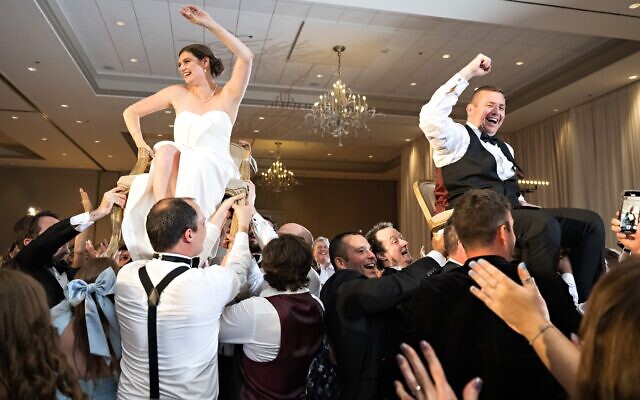 The bride and groom are celebrated with the Hora among family and friends
