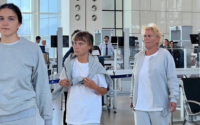 Swedish activist Greta Thunberg (center) at Ramon International Airport on Oct. 6, 2025, before being deported along with other Gaza flotilla activists // Photo Credit: Foreign Ministry/Times of Israel Swedish activist Greta Thunberg (center) at Ramon International Airport on Oct. 6, 2025, before being deported along with other Gaza flotilla activists // Photo Credit: Foreign Ministry/Times of Israel