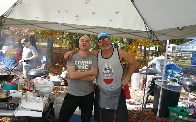 A pair of teammates from Holy Smokes BBQ take a quick break from cooking to pose for a photo. A pair of teammates from Holy Smokes BBQ take a quick break from cooking to pose for a photo.