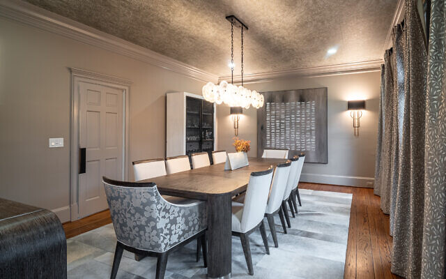 The home’s dining room evokes glamour with touches like eye-catching wallpaper, glamorous scones, and a chandelier. 