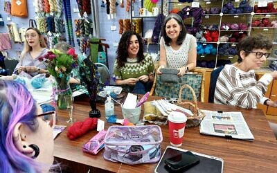 Owner DeAnne Jacobson and sister, Lori London, stop by a table of knitters. Owner DeAnne Jacobson and sister, Lori London, stop by a table of knitters.