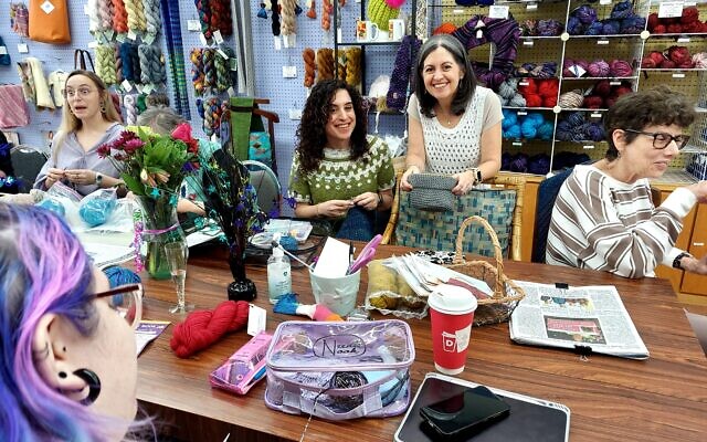 Owner DeAnne Jacobson and sister, Lori London, stop by a table of knitters. Owner DeAnne Jacobson and sister, Lori London, stop by a table of knitters.