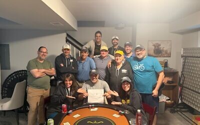Henri Banamran is seated surrounded by Toco Hills Poker League players displaying his $269,000 check.