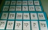 Israeli voters choose one of the slips of papers with party symbols printed that are on trays at voting stations.