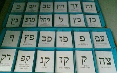 Israeli voters choose one of the slips of papers with party symbols printed that are on trays at voting stations.