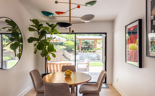 The dining area off the kitchen has an eclectic, contemporary feel with an abundance of natural light. Laura took great care in finding the perfect colorful “starburst” lighting and a vintage table that is paired with modern velvet dining chairs. 