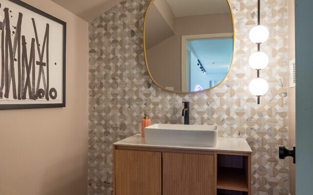 Laura took great care designing this Wabi Sabi powder room with travertine and marble tile and a simple floating vanity.