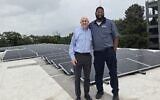 Temple Executive Director Jeremy Perlin (left) with Temple Maintenance Manager Lonnie Fitzgerald on the rooftop where solar panels are generating electricity for the midtown synagogue.