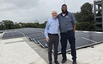 Temple Executive Director Jeremy Perlin (left) with Temple Maintenance Manager Lonnie Fitzgerald on the rooftop where solar panels are generating electricity for the midtown synagogue.