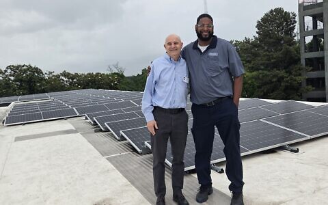 Temple Executive Director Jeremy Perlin (left) with Temple Maintenance Manager Lonnie Fitzgerald on the rooftop where solar panels are generating electricity for the midtown synagogue.