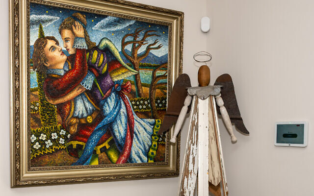 Lamar Smith’s provocative, “Capture,” is pictured alongside a wooden angel Gary found “retail” in Roswell.