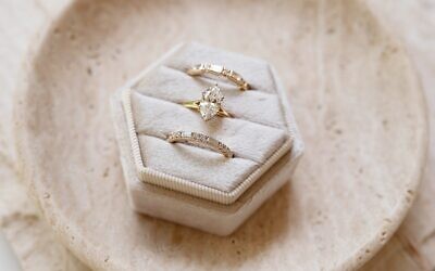 A custom marquise diamond engagement ring paired with coordinating bands reflects Brilliant’s approach to modern bridal jewelry. 