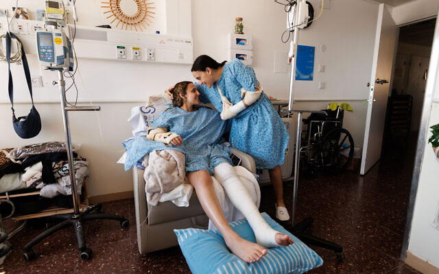 Former hostages Emily Damari and Romi Gonen embrace in the hospital after surgery.