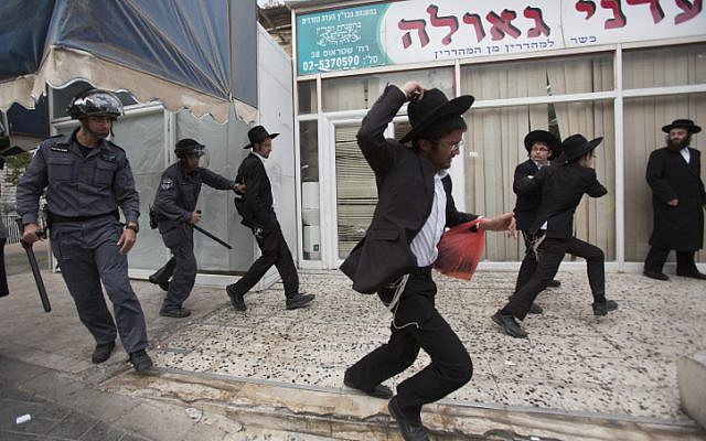 Illustrative: Ultra-Orthodox Jews with police to protest against a national draft bill, Jerusalem, April 10, 2014. (Yonatan Sindel/Flash90/File)
