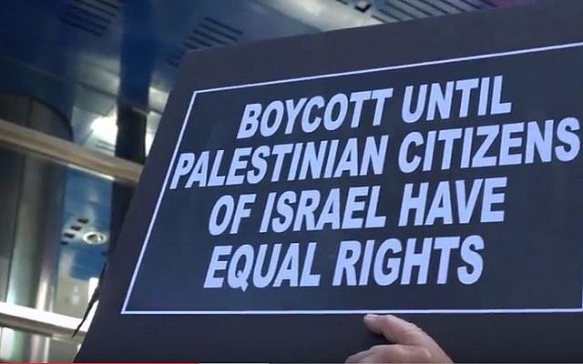 Illustrative: A protester against anti-BDS legislation holds a sign in front of Governor Cuomo's NYC offices on June 9, 2016. (screen capture: YouTube)