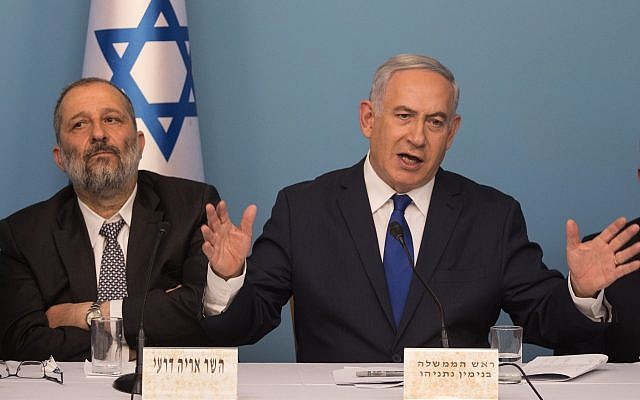 Prime Minister Benjamin Netanyahu (right) and Interior Minister Aryeh Deri announce a new refugee deal with the UN, hours before suspending it, April 2, 2018 (Hadas Parush/Flash90)