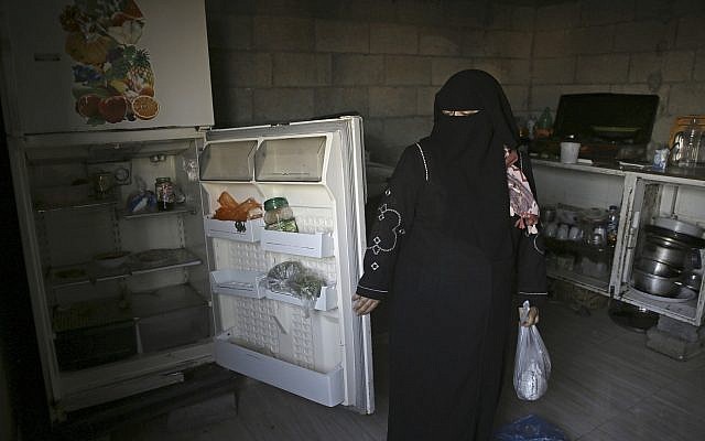 Samia Hassan shows her family's nearly empty refrigerator in Gaza City, May 31, 2018. (AP Photo/Adel Hana)
