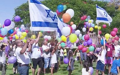 Children and residents of Kibbutz Nir Am release balloons carrying candy towards the Gaza Strip on June 15, 2018. (Screen capture: Hadashot TV News)
