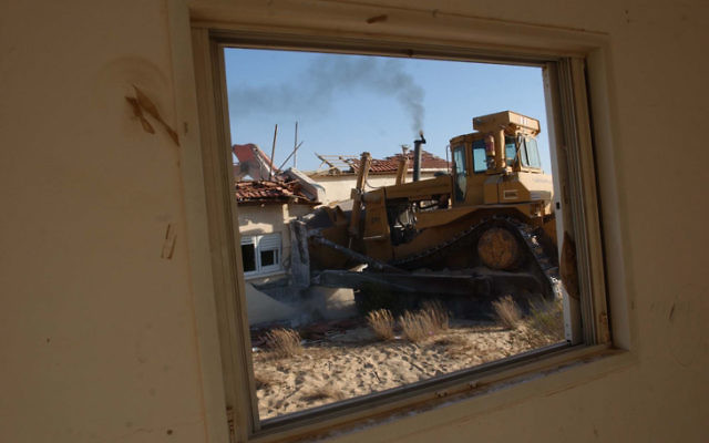 A backhoe demolishes a house in the settlement of Payat Sade during the 2005 disengagement from Gush Katif. (Flash90)