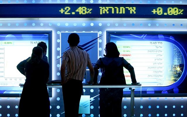 People watch a board showing stock fluctuations at the Tel Aviv stock exchange. (photo credit: Moshe Shai/FLASH90)