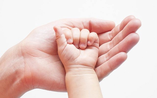 Illustrative. Baby's hand in hand. (via Shutterstock)