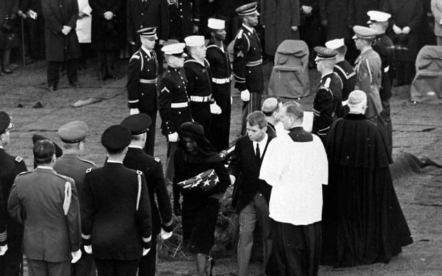 Jackie and Robert Kennedy walk away from the grave