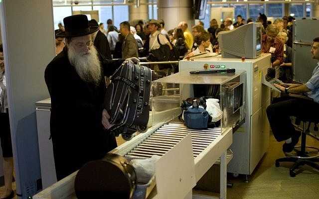 illustrative: Passengers have their hand luggage screened by security personnel at Ben-Gurion Airport, file photo (Ariel Schalit/AP)