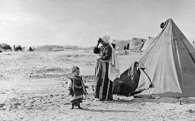 In this 1948 photo from the UNRWA archive, Palestinian refugees stand outside their tent in Khan Younis, Gaza Strip. (photo credit: AP/UNRWA Photo Archives)