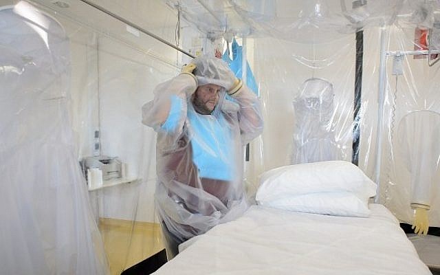A nurse wears protective clothing as he demonstrates the facilities in place at the Royal Free Hospital in north London on August 6, 2014, in preparation for a patient testing positive for the Ebola virus (Photo credit: Leon Neal/AFP)