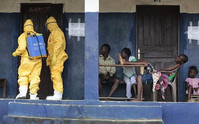 Medical personnel disinfect a room where suspected Ebola sufferers were quarantined in the village of Freeman Reserve, Liberia, September 30, 2014.  (Illustrative photo: AP/Jerome Delay, File)