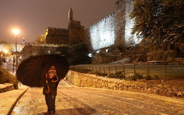 A young girl walks with an umbrella near the walls of the Old City of Jerusalem a winter storm hits Israel, January 07, 2015. (photo credit: Nati Shohat/FLASH90)