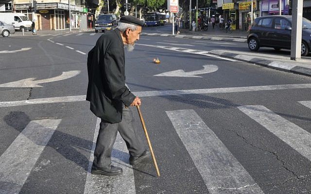 Illustrative: An elderly man crosses the street in Tel Aviv, May 20, 2009 (Serge Attal/Flash 90)