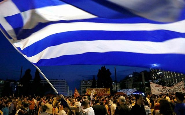 A demonstrator waves a Greek flag during an anti-austerity rally in central Athens, Friday, July 10, 2015. (AP Photo/Petros Karadjias)