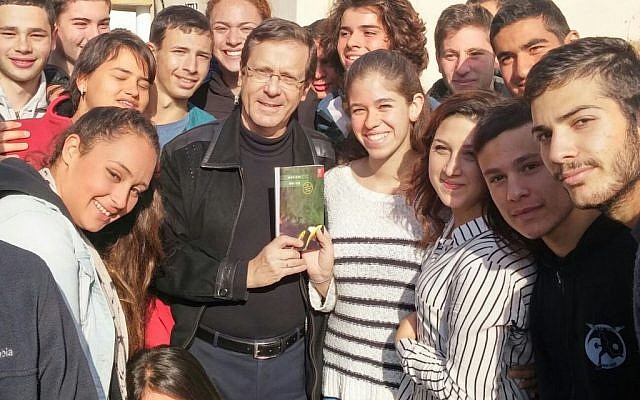 Opposition leader Issac Herzog posing with a copy of Dorit Rabinyan's "Gader Haya" surrounded by students at the pre-army academy in Sderot, December 31, 2015. (Photo by Zionist Union)