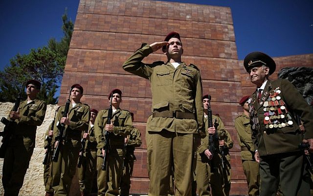 A World War II veteran walks past an honor guard of Israeli soldiers during the annual Holocaust Remembrance Day ceremony at the Yad Vashem Holocaust Memorial in Jerusalem on May 5, 2016. (AFP Photo/Gali Tibbon)