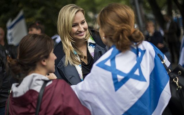 Illustrative: Ebba Busch Thor (C), head of the Christian Democratic Party in Sweden, is greeted by an Israel-flag-draped woman during a 'Taking Back Zionism' pro-Israel rally at Raoul Wallenberg Square in Stockholm on August 28, 2016. (AFP PHOTO/JONATHAN NACKSTRAND)