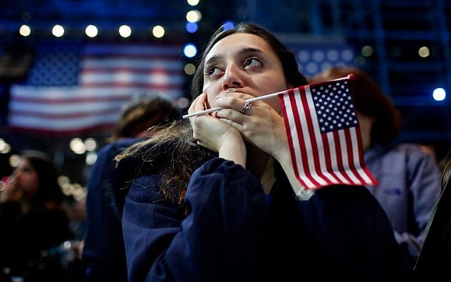 A woman holds an American flag as she watches the voting results at Democratic presidential nominee former Hillary Clinton's election night event at the Jacob K. Javits Convention Center in New York City on November 9, 2016. (Win McNamee/Getty Images/AFP)
