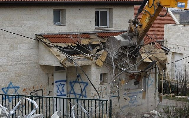 A bulldozer destroys a home built on private Palestinian land in the West Bank settlement of Ofra on March 1, 2017. (AFP Photo/Menahem Kahana)