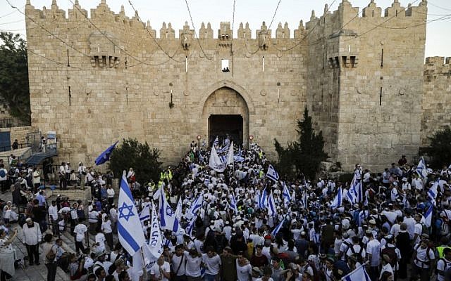 Israelis wave the Israeli flag as they parade through Damascus Gate in Jerusalem's Old City on May 24, 2017 to commemorate Jerusalem Day, marking the reunification of the city following the Six-Day War of 1967. (AFP PHOTO / Menahem KAHANA)