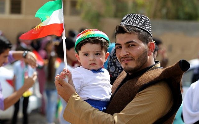 An Iraqi Kurdish man poses as he carries a child wearing the Kurdish flag on his head during a celebration in the northern city of Kirkuk on September 25, 2017, as Iraqi Kurds vote in a referendum on independence. (AFP Photo/Ahmad Al-Rubaye)