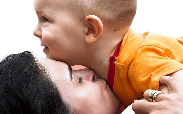One year old baby and his mother are playing together. The mother gives a kiss and the baby is smiling. (iStock)