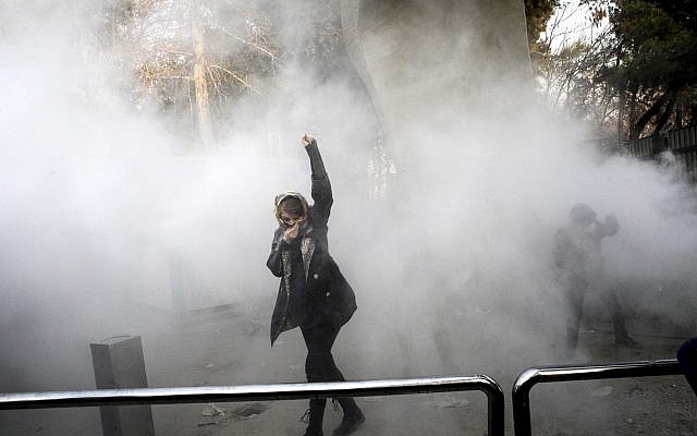 University students attend an anti-regime protest inside Tehran University while a smoke grenade is thrown by Iranian anti-riot police, in Tehran, Iran, December 30, 2017. (AP Photo)