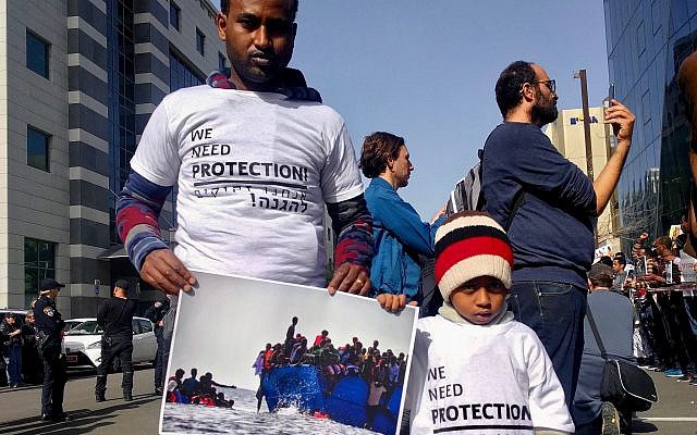 A father and son protest the planned deportations outside of the Rwandan Embassy on January 22, 2018. (Melanie Lidman/Times of Israel)