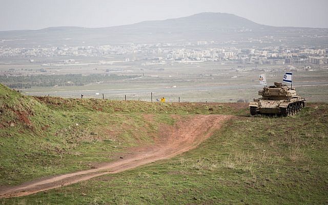 An old Israeli tank with a flag overlooking the Syrian town of Quneitra in the Golan Heights on February 11, 2018. (Hadas Parush/Flash90)