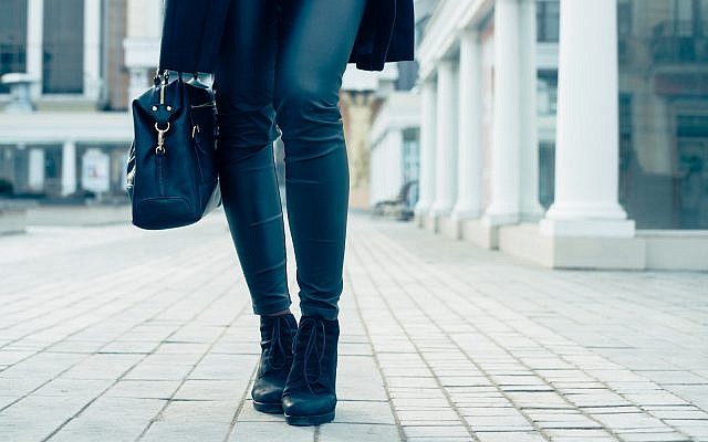 Closeup of female legs in black pants and boots. Woman walking in the city. (iPhoto)