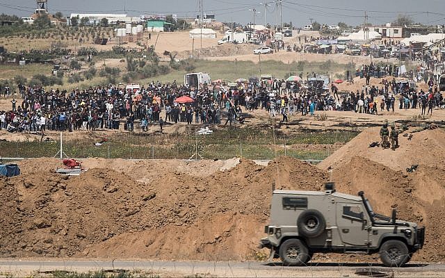 IDF soldiers on the Israeli side of the border with the Gaza Strip as thousands of Palestinians demonstrate near the border fence, April 6, 2018. (Hadas Parush/Flash90)