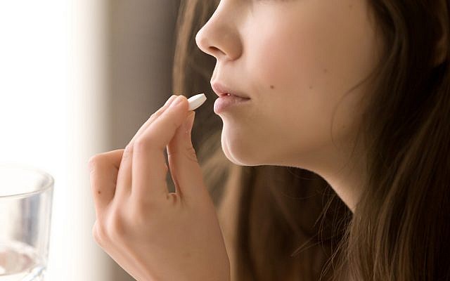 Illustrative: Close up of woman putting white round pill in mouth.  (iStock)