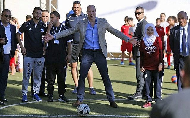 Britain's Prince William (C) prepares to shoot a soccer ball during his meeting with young Palestinian soccer players in the West Bank city of Ramallah on June 27, 2018. (AFP Photo/Abbas Momani)