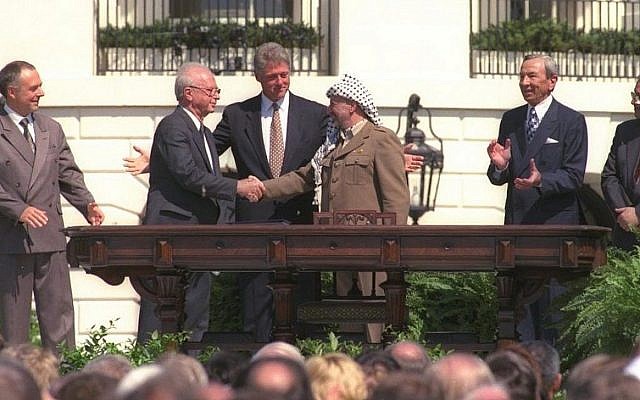 Bill Clinton looks on as Yitzhak Rabin and Yasser Arafat shake hands during the historic signing of the Oslo Accords, September 13, 1993. On the far right, current Palestinian leader Mahmoud Abbas (GPO)